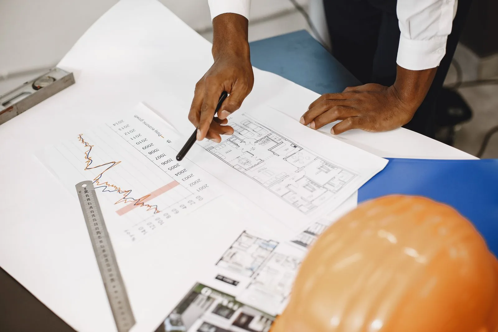 Bouwplannen met meetlat en helm op de ontwerptafel