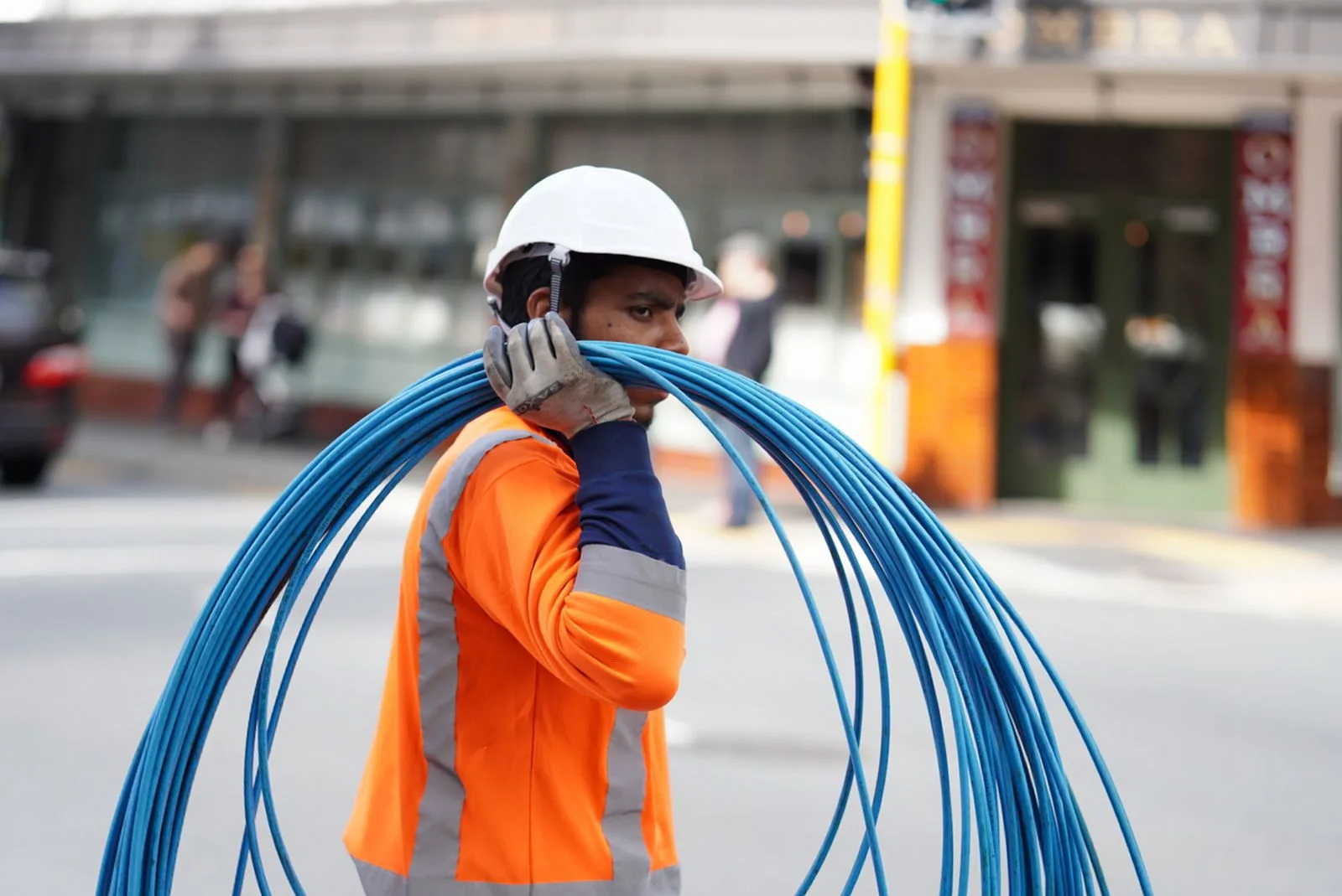 Technieker met een rol kabel op straat