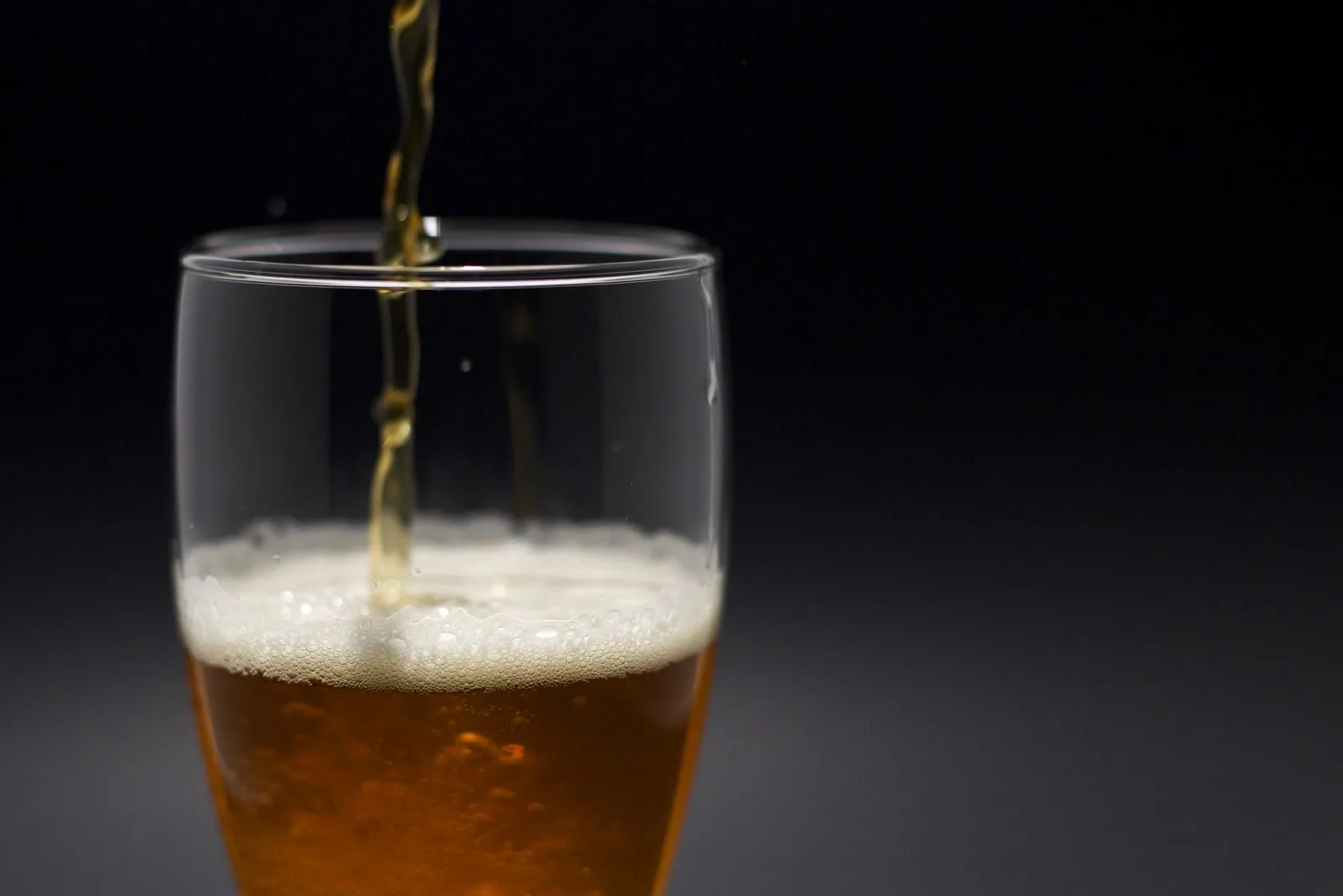 Goudblond bier dat in een glas geschonken wordt