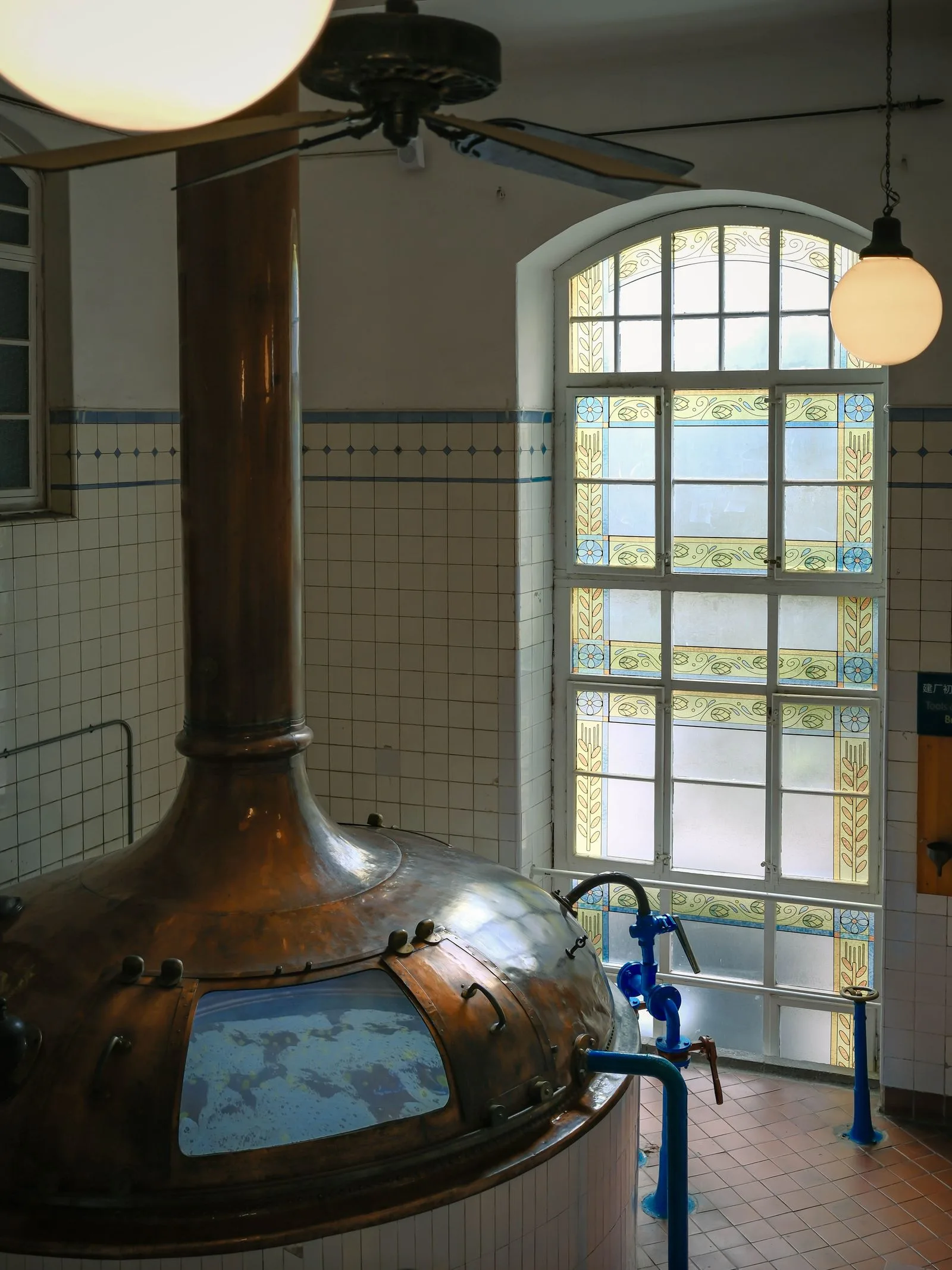 Koperen brouwketel in een brouwzaal met hoge ramen