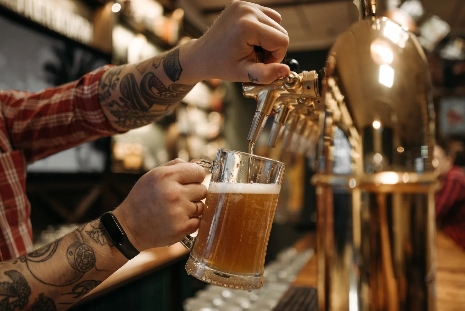 Brouwer tapt een vers bier aan de koperen kranen van de taproom
