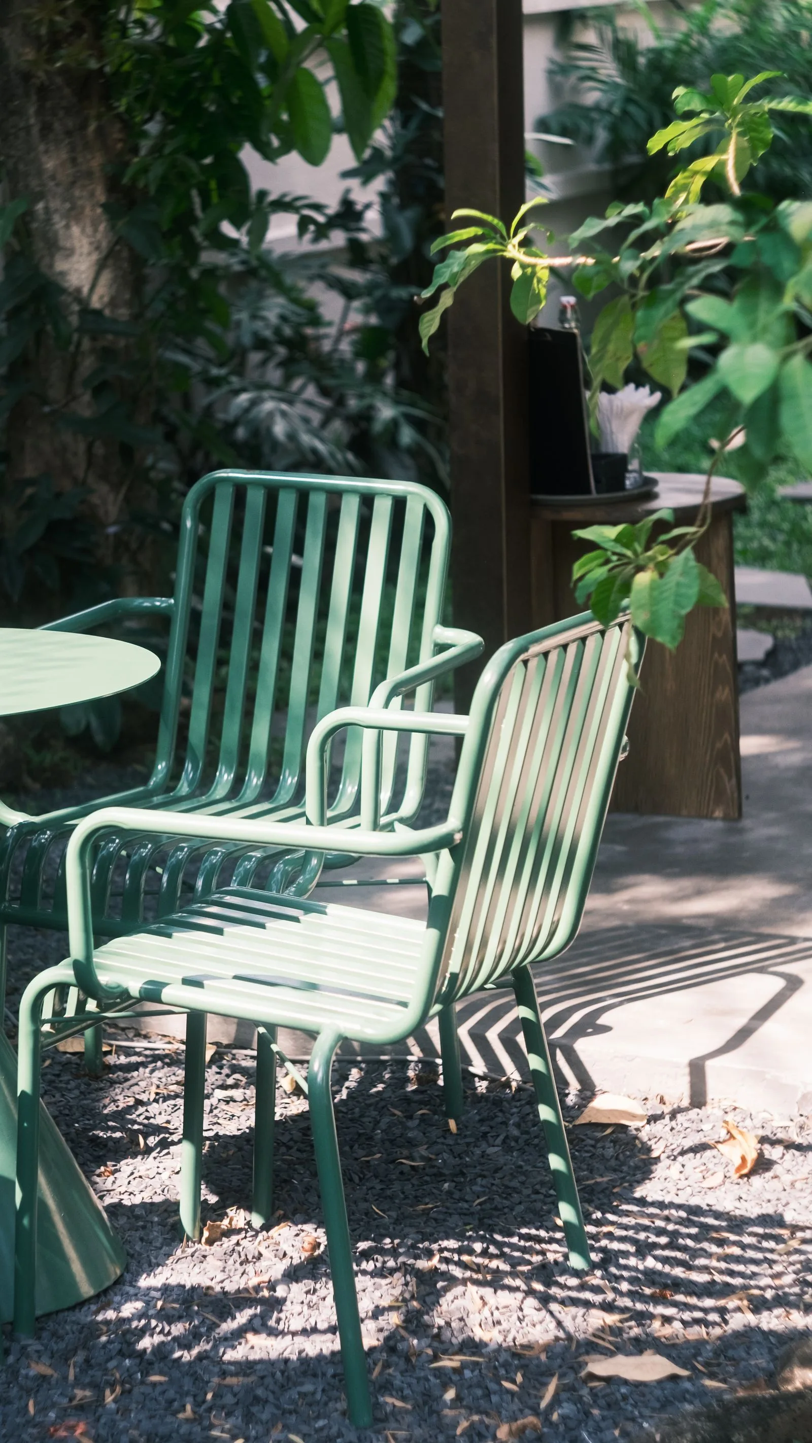 Groene metalen stoelen op een zonnig terras