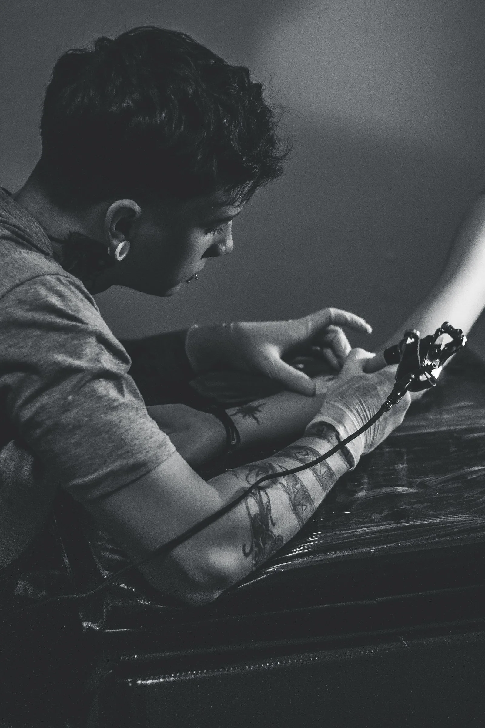 Tattoo-artiest geconcentreerd aan het werk in de studio