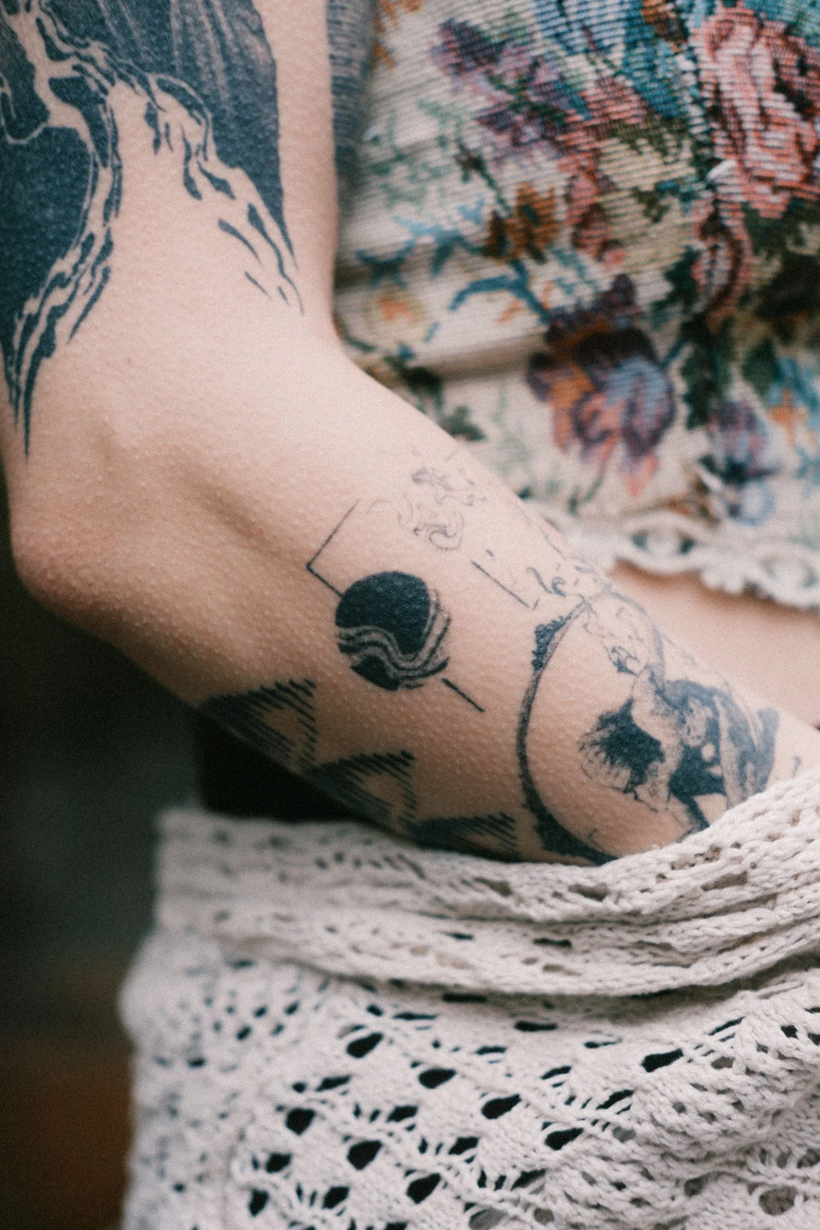 Arm met verschillende tattoos in zwart en blauw