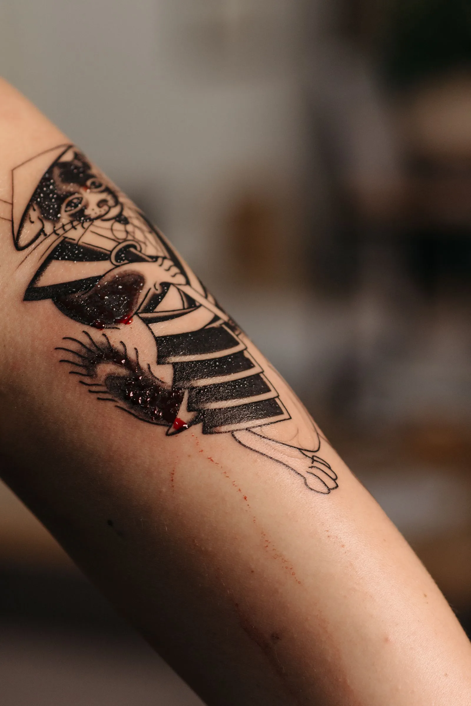 Verse tattoo in zwart en rood op een onderarm