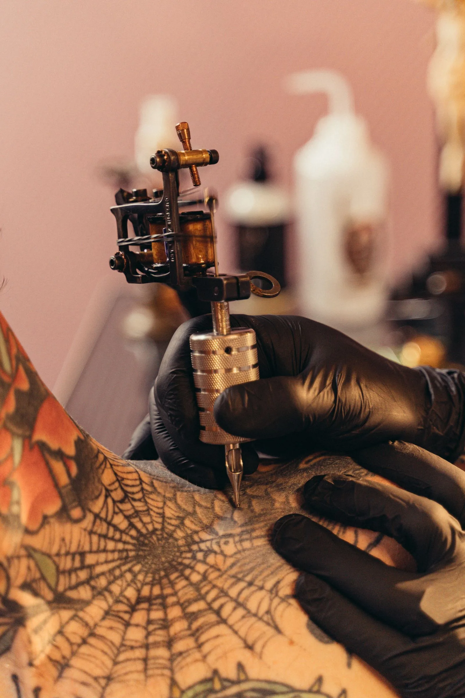 Tattoo-artiest zet een spinnenweb met een tattoomachine