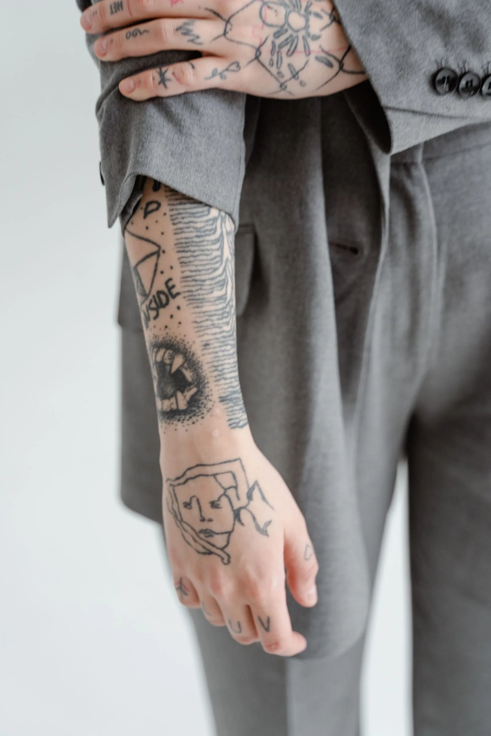 Hand en onderarm met kleine tattoos in zwart