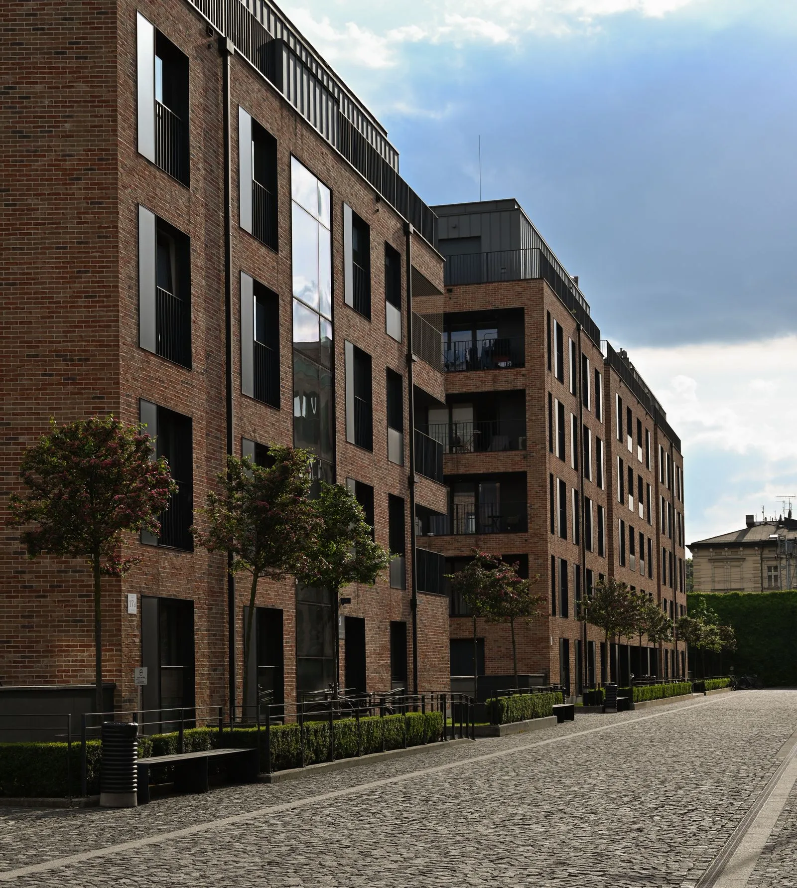Appartementsgebouwen in baksteen langs een gekasseide straat