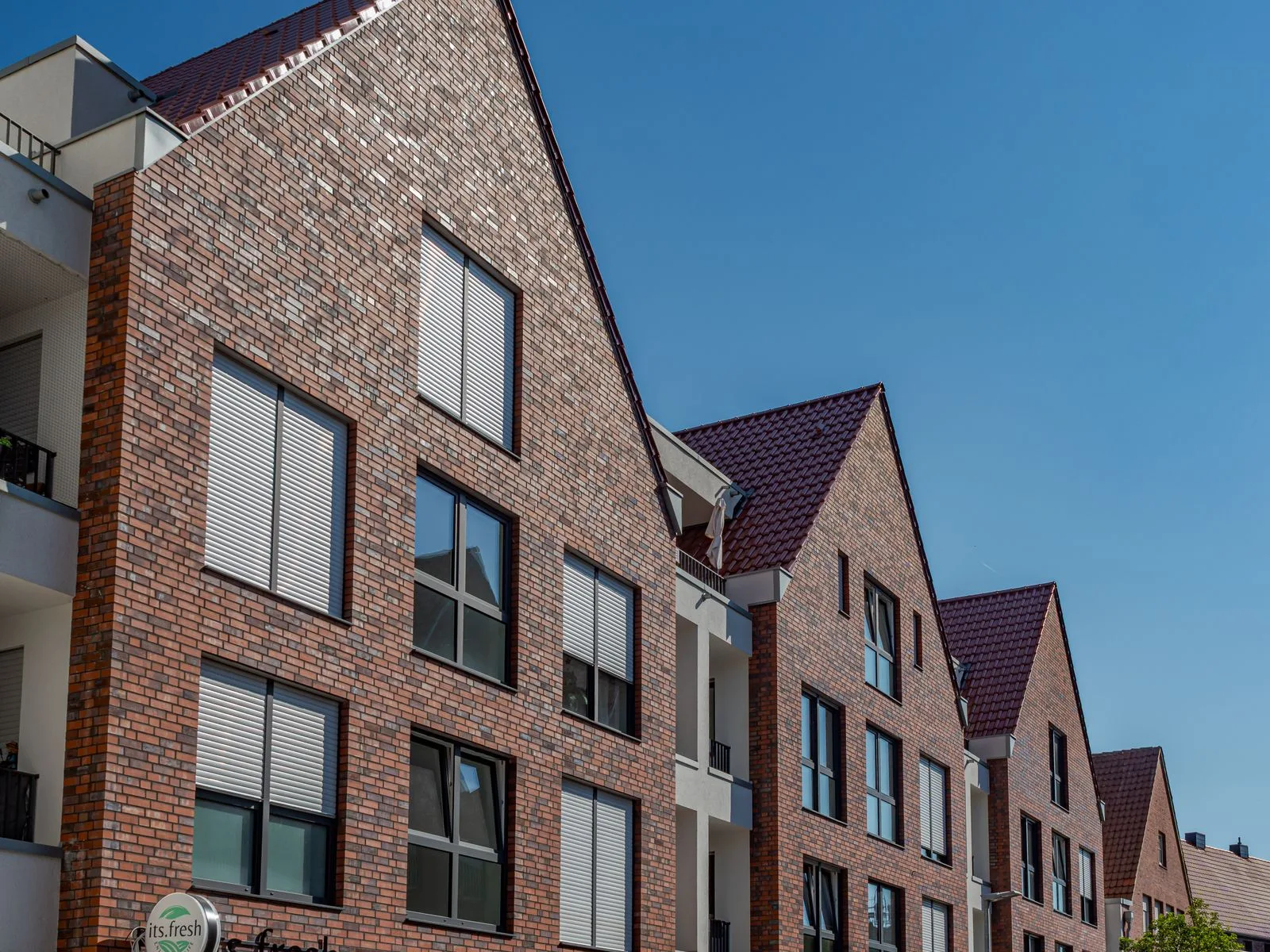 Nieuwe residentie in baksteen met appartementen onder een blauwe lucht