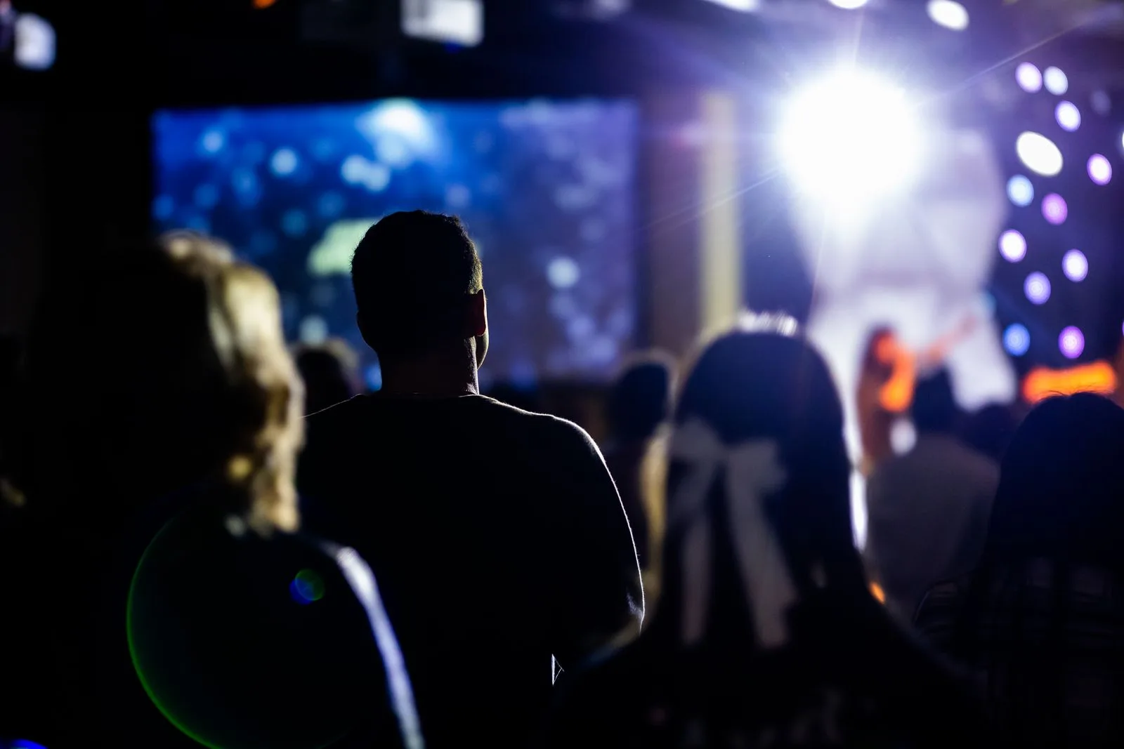 Publiek kijkt naar een podium met lichtshow