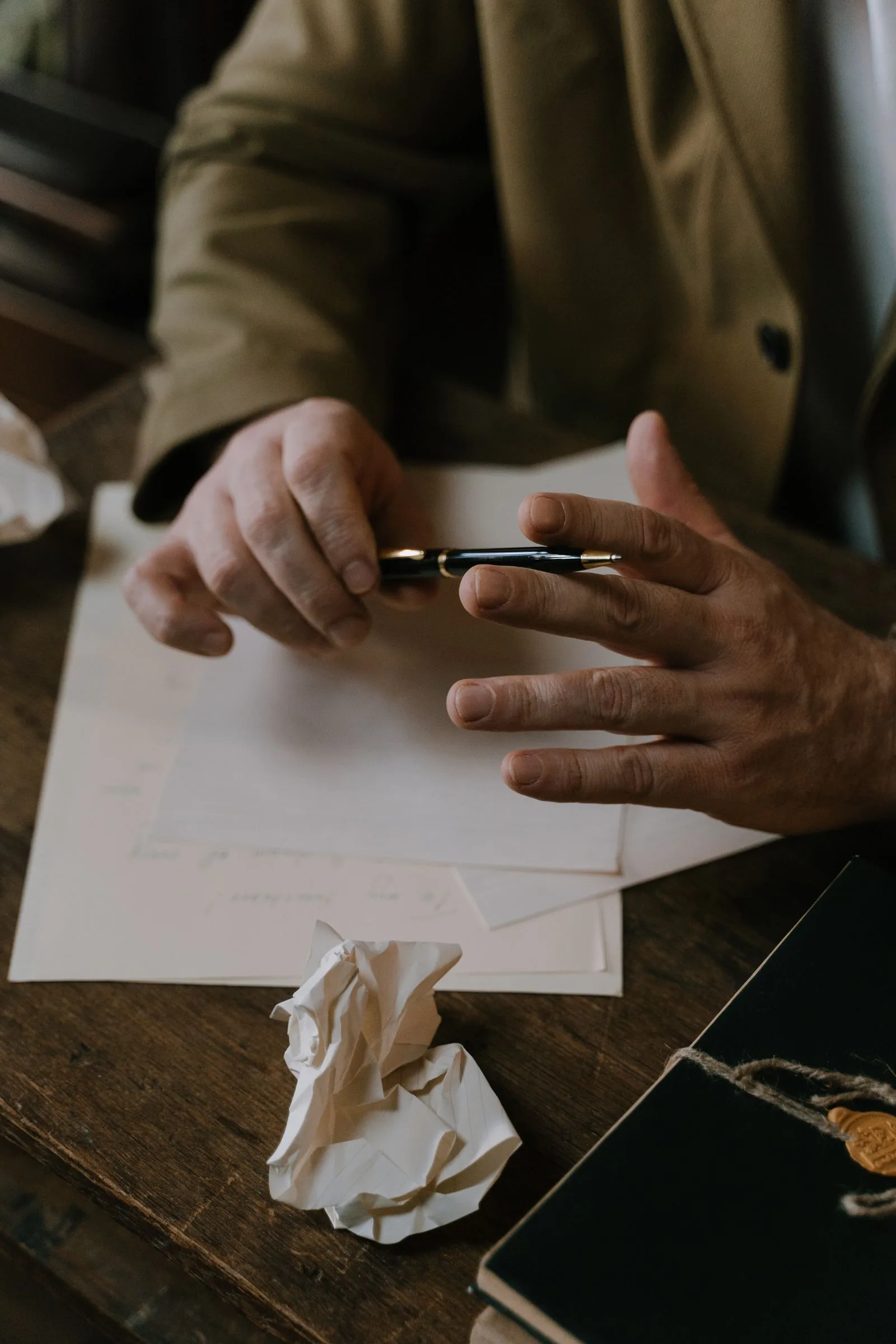 Pen en papier op een werktafel met een verfrommeld blad