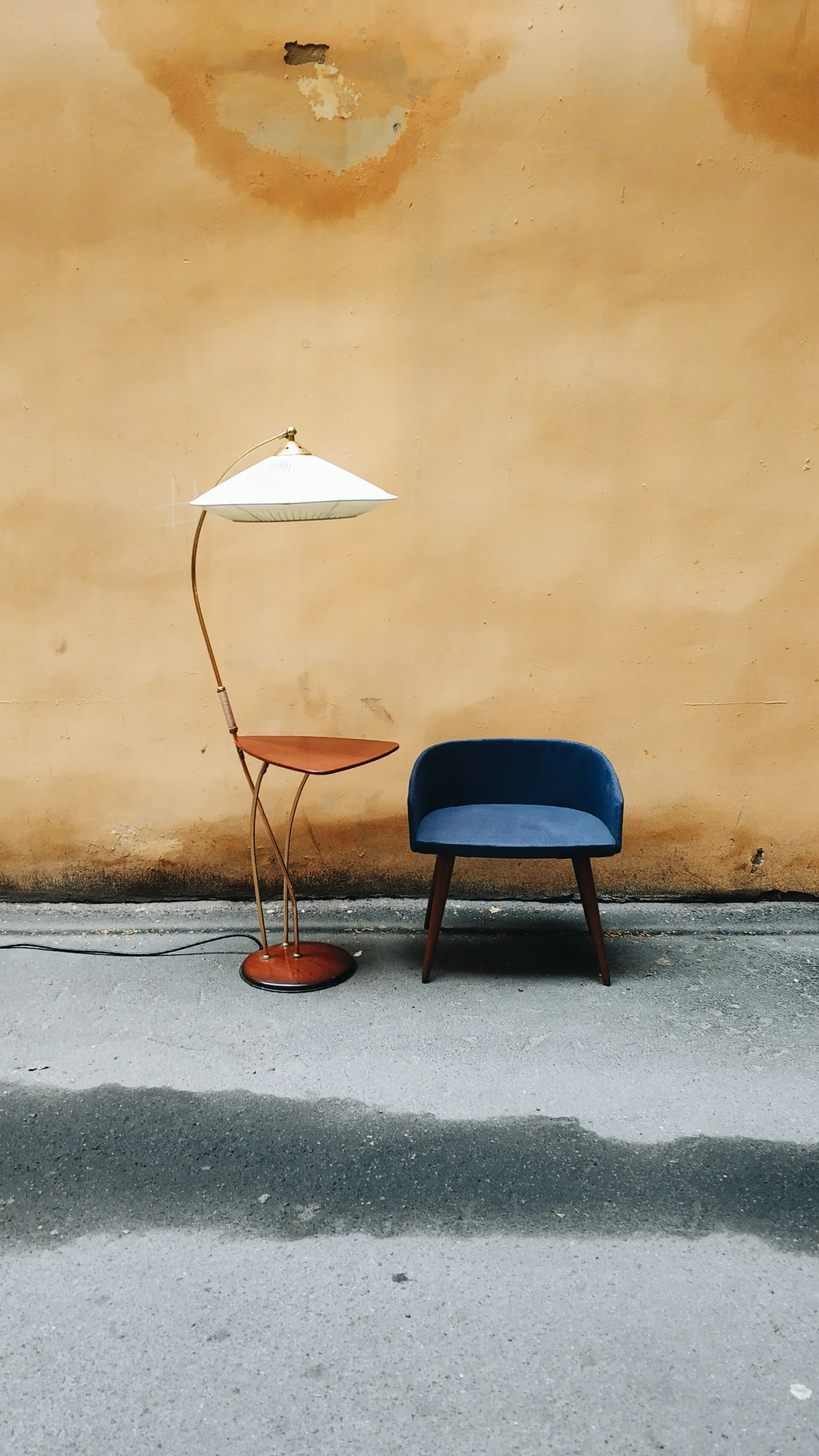 Retro staanlamp naast een blauwe fauteuil
