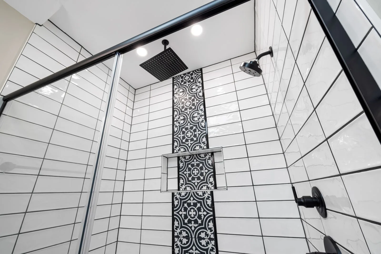 Inloopdouche met witte wandtegels en een strook decortegels