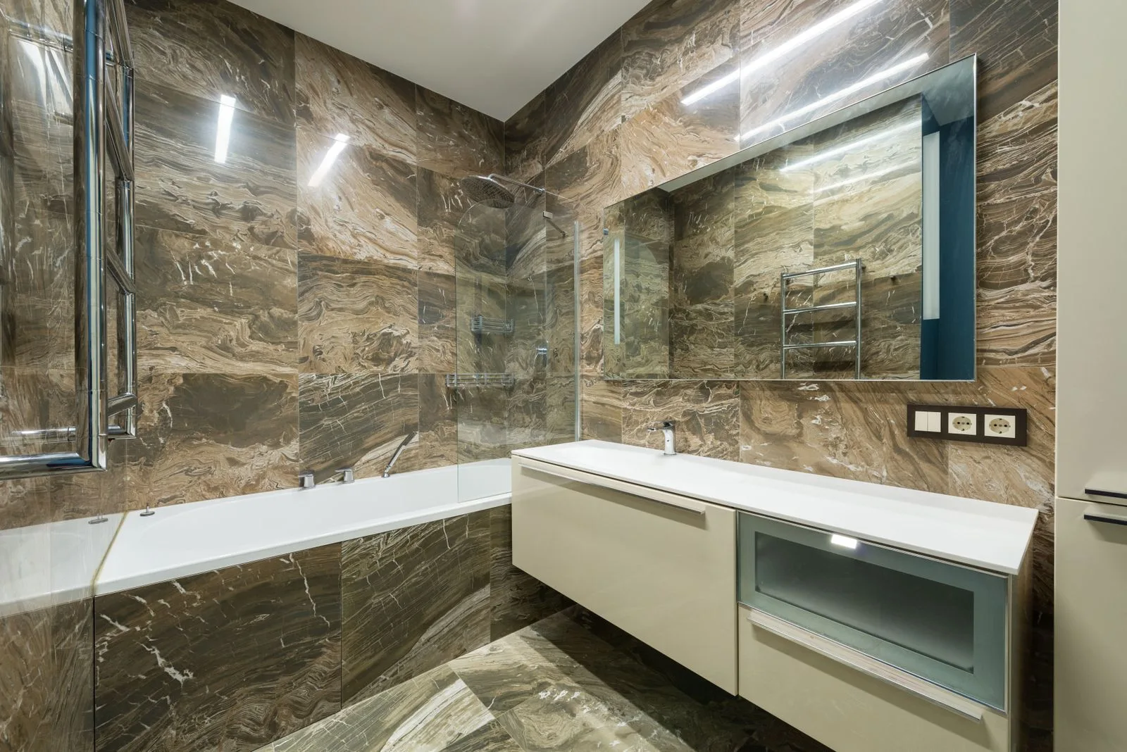 Badkamer met wanden en bad in tegels met marmerlook