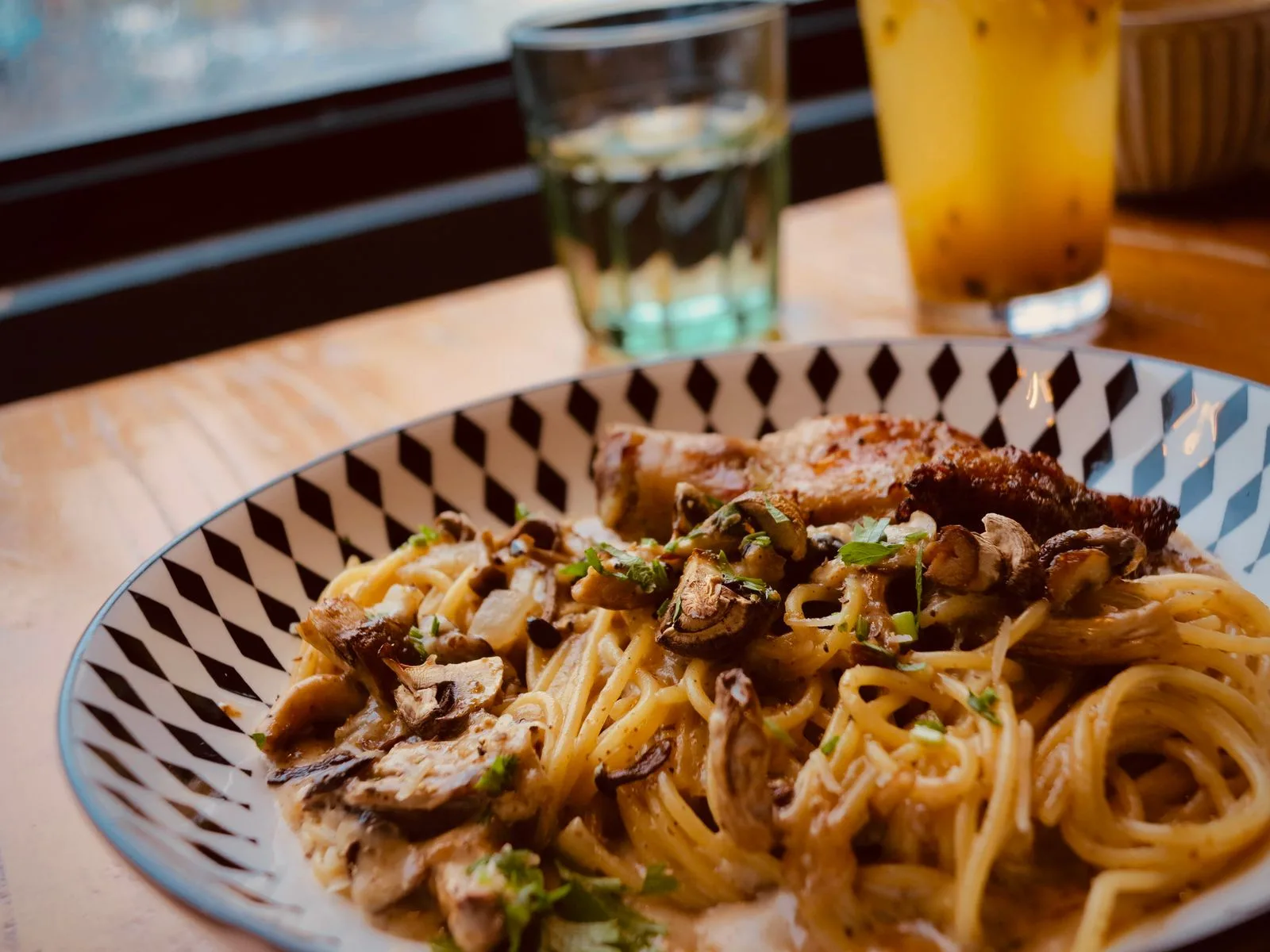 Spaghetti met champignons op een bord met ruitmotief