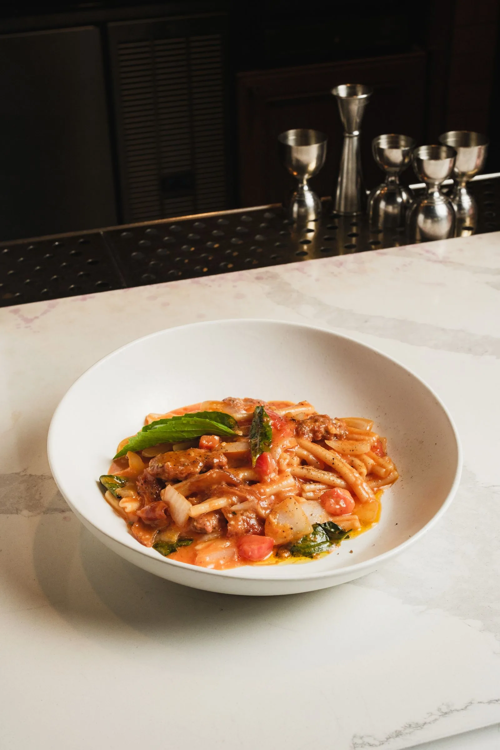 Pasta met tomatensaus op een marmeren toog